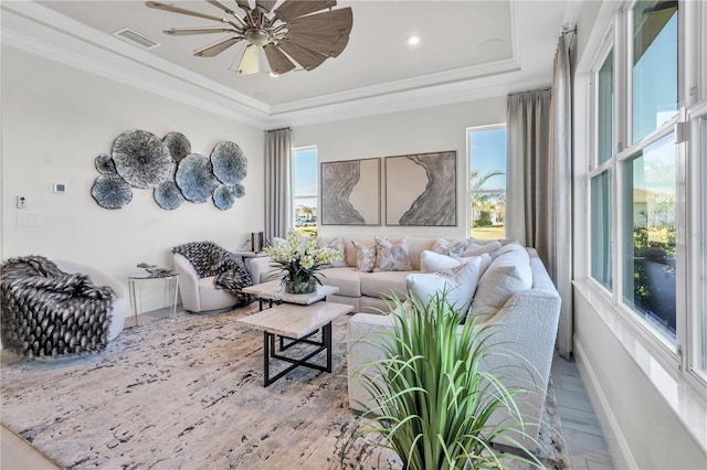 living room featuring a raised ceiling, ceiling fan, crown molding, and wood-type flooring