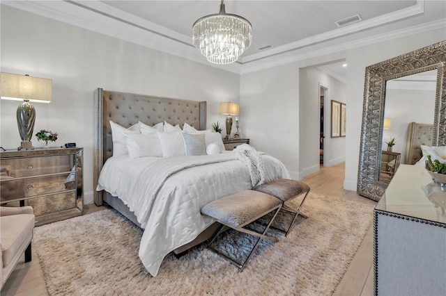 bedroom featuring light wood-type flooring, an inviting chandelier, and crown molding