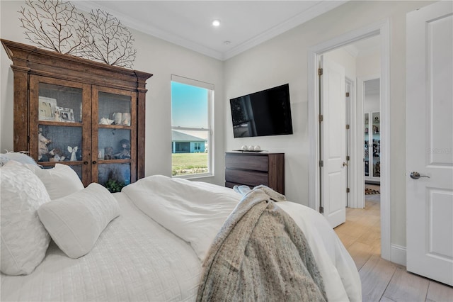 bedroom with crown molding and light hardwood / wood-style flooring