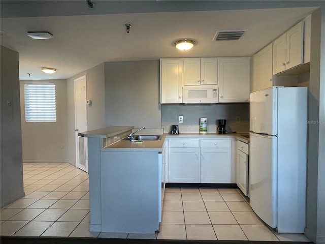 kitchen with kitchen peninsula, sink, light tile patterned flooring, white appliances, and white cabinetry