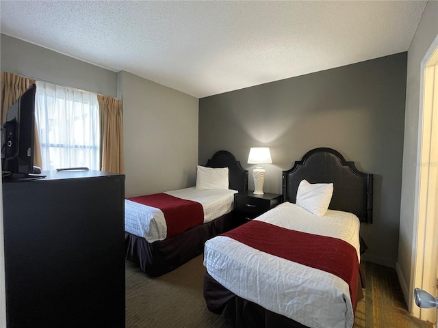 bedroom with dark wood-type flooring and a textured ceiling