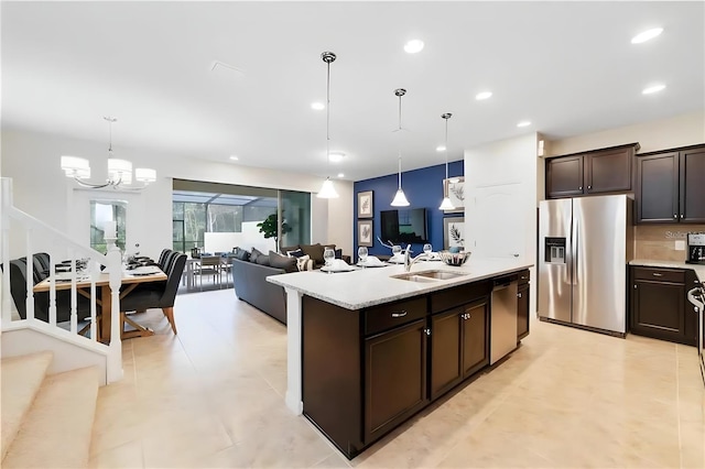 kitchen with pendant lighting, dark brown cabinetry, sink, and appliances with stainless steel finishes