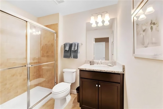 bathroom featuring tile patterned floors, vanity, toilet, and a shower with shower door