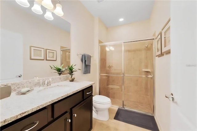 bathroom featuring tile patterned flooring, vanity, toilet, and a shower with door