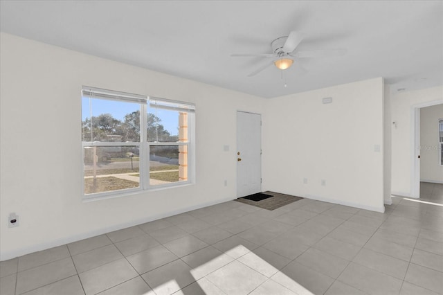 empty room featuring light tile patterned floors and ceiling fan