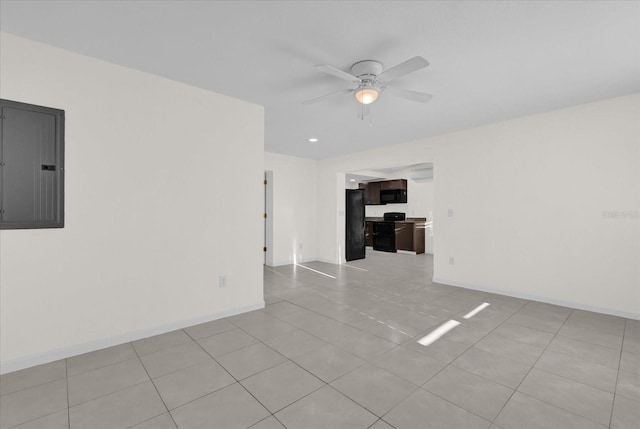 tiled empty room featuring electric panel and ceiling fan