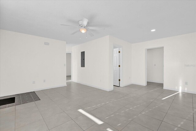 tiled spare room featuring electric panel and ceiling fan