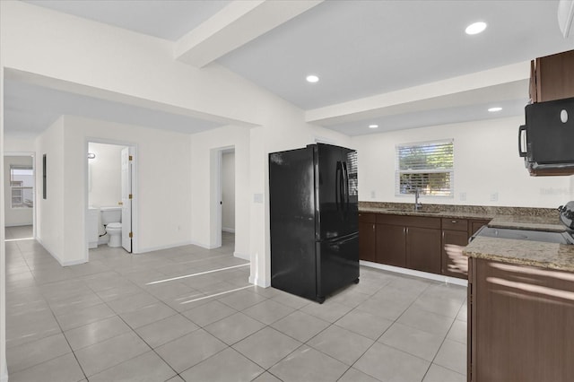 kitchen featuring sink, light tile patterned floors, beam ceiling, dark brown cabinets, and black appliances