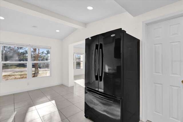 kitchen with black refrigerator, lofted ceiling with beams, and light tile patterned flooring