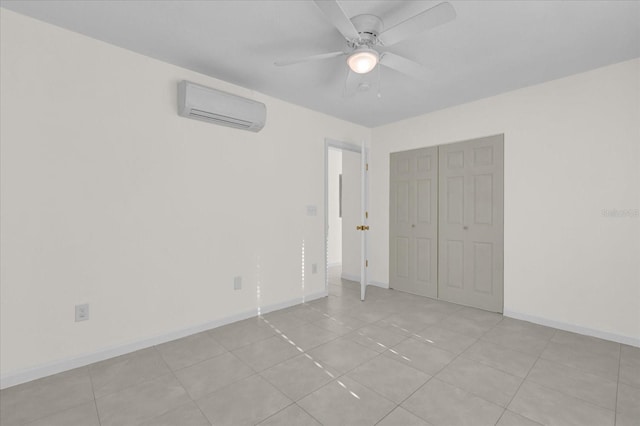 unfurnished bedroom with a wall mounted air conditioner, light tile patterned floors, a closet, and ceiling fan