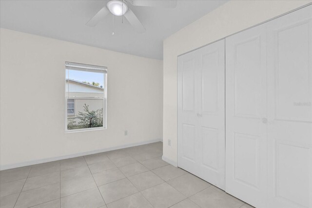 unfurnished bedroom featuring ceiling fan, a closet, and light tile patterned floors