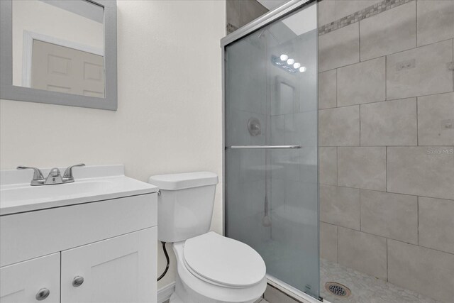 bathroom with vanity, an enclosed shower, and toilet