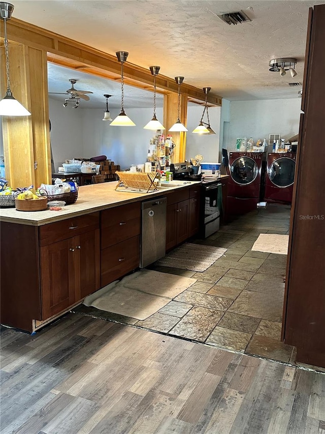 kitchen with dark brown cabinetry, washing machine and dryer, stainless steel appliances, hanging light fixtures, and ceiling fan