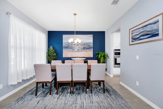 tiled dining area featuring an inviting chandelier