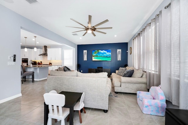 tiled living room featuring ceiling fan, sink, and a wealth of natural light