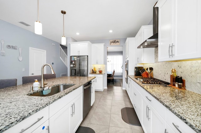 kitchen featuring backsplash, white cabinets, hanging light fixtures, sink, and appliances with stainless steel finishes