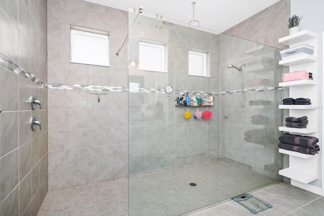 bathroom featuring tile patterned flooring, a healthy amount of sunlight, and a tile shower