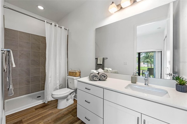 bathroom with a shower with shower curtain, wood-type flooring, vanity, and toilet