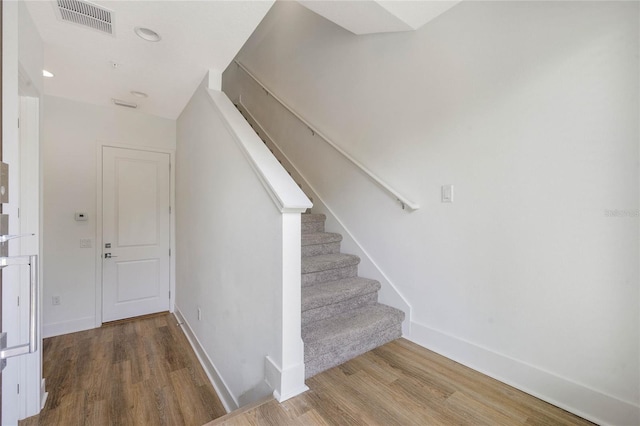 stairs featuring hardwood / wood-style floors