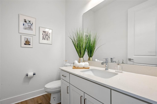 bathroom with hardwood / wood-style floors, vanity, and toilet