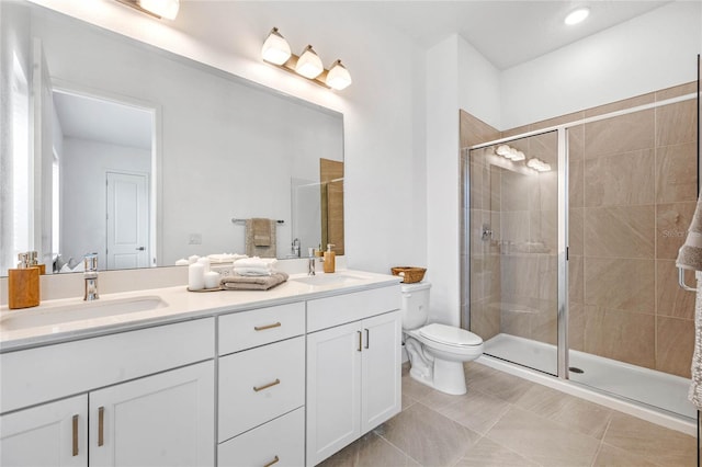 bathroom featuring tile patterned flooring, vanity, toilet, and a shower with shower door