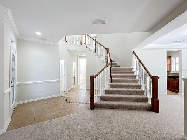 entrance foyer with light tile patterned flooring and ornamental molding