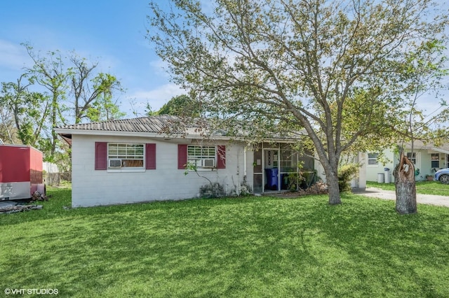 ranch-style home featuring cooling unit, metal roof, and a front lawn