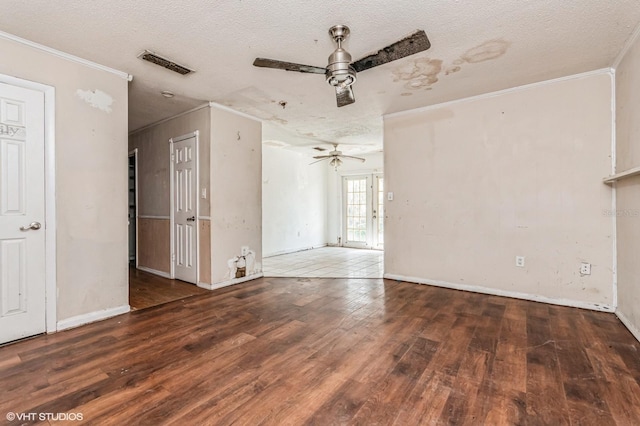 unfurnished room with ceiling fan, hardwood / wood-style floors, visible vents, and crown molding