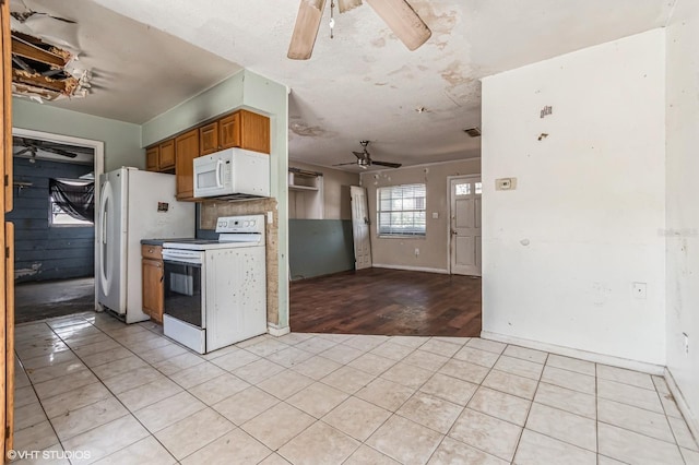 kitchen with a ceiling fan, white appliances, light tile patterned flooring, and brown cabinetry