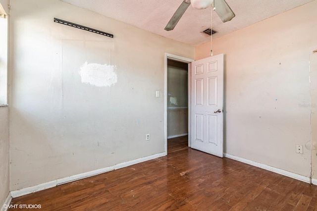 spare room featuring baseboards, visible vents, ceiling fan, wood finished floors, and a textured ceiling