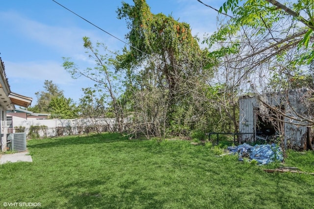 view of yard with fence and central AC unit