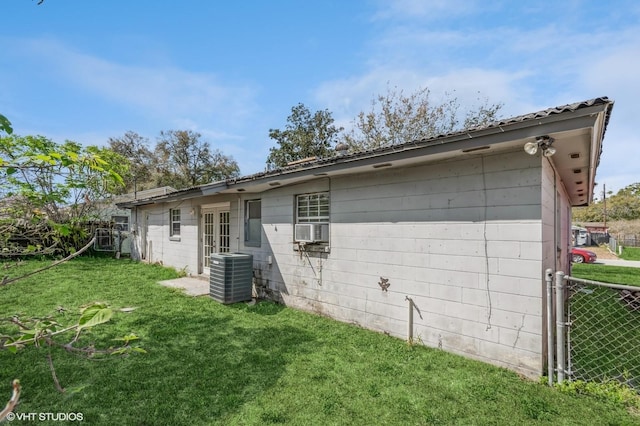 exterior space featuring central AC, a front yard, fence, and cooling unit