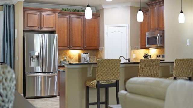 kitchen with sink, a kitchen breakfast bar, crown molding, pendant lighting, and appliances with stainless steel finishes