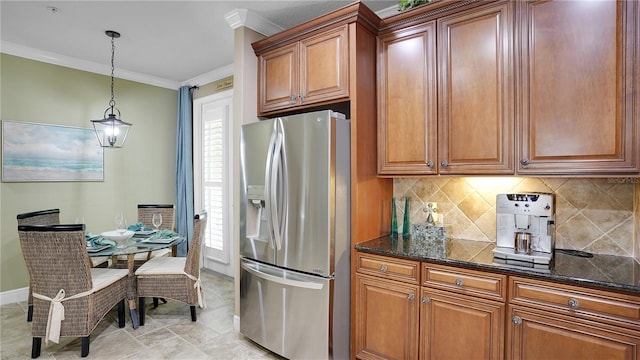 kitchen featuring a wealth of natural light, stainless steel fridge with ice dispenser, dark stone counters, decorative light fixtures, and ornamental molding