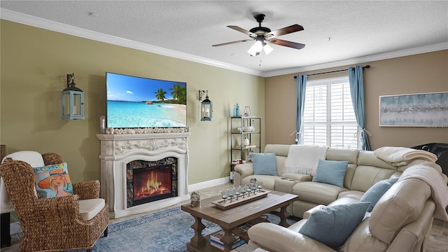 living room with a premium fireplace, crown molding, ceiling fan, and a textured ceiling