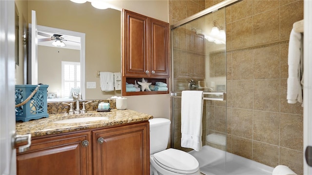 bathroom featuring vanity, ceiling fan, an enclosed shower, and toilet