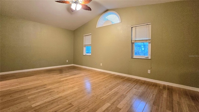 spare room featuring ceiling fan, lofted ceiling, and light wood-type flooring