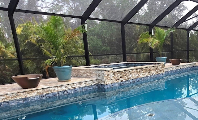 view of swimming pool featuring glass enclosure and an in ground hot tub