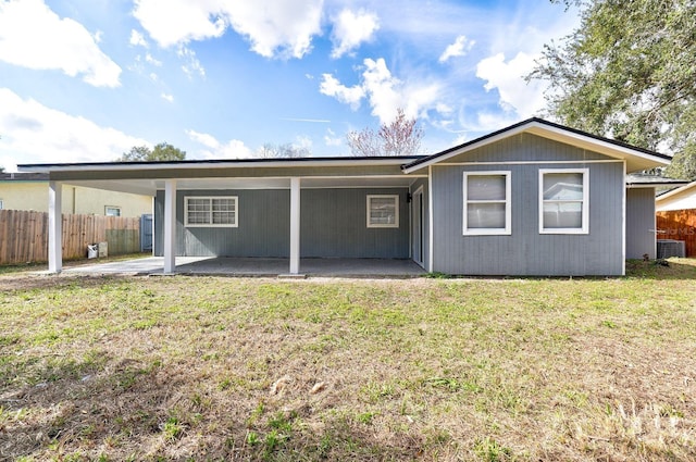 back of property with central air condition unit, a patio area, and a yard