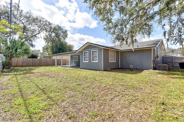 back of property with cooling unit, a patio area, and a lawn