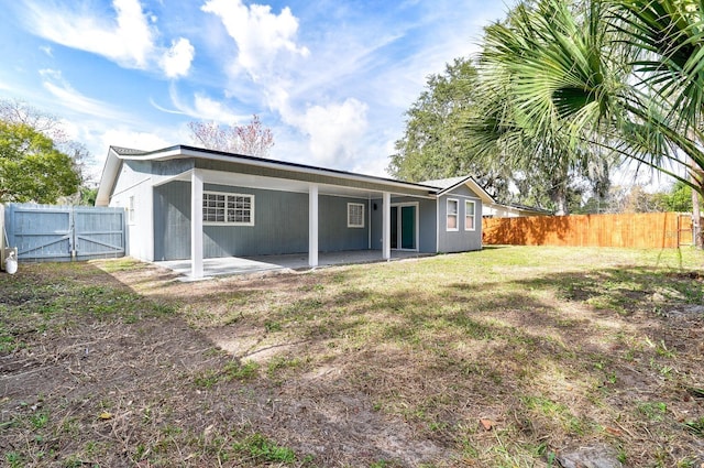 back of property with a yard and a patio