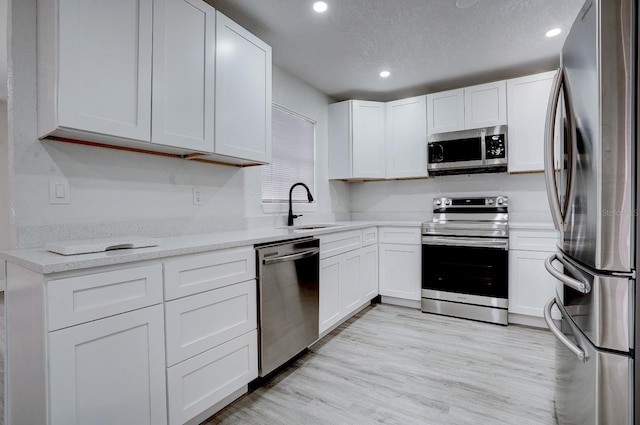 kitchen with white cabinetry, sink, and appliances with stainless steel finishes