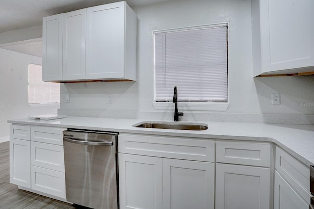 kitchen featuring dishwasher, light hardwood / wood-style flooring, white cabinetry, and sink