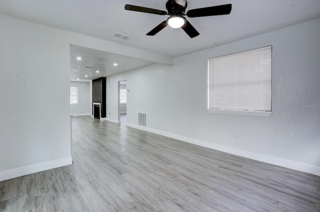 empty room with ceiling fan and light wood-type flooring