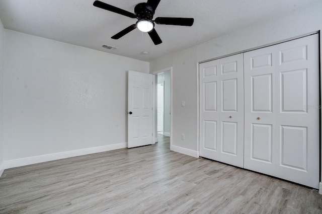 unfurnished bedroom with ceiling fan, a closet, and light wood-type flooring