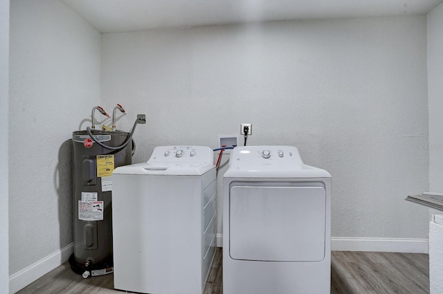 washroom with washer and clothes dryer, hardwood / wood-style flooring, and water heater