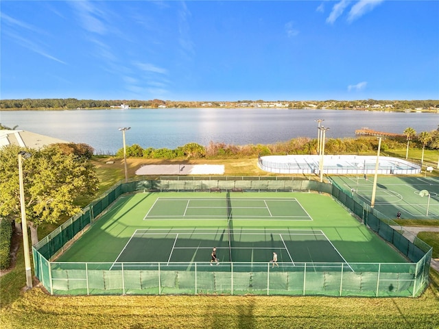 view of tennis court with a water view