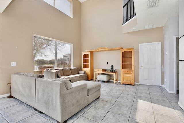 living room with light tile patterned floors and a high ceiling