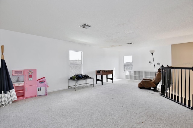 game room with carpet floors and a textured ceiling