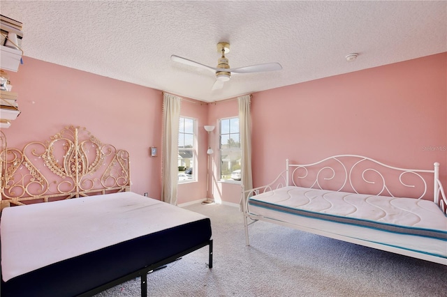 carpeted bedroom featuring ceiling fan and a textured ceiling